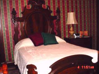 queen size bed with beautiful headboard at courthouse inn bed and breakfast
